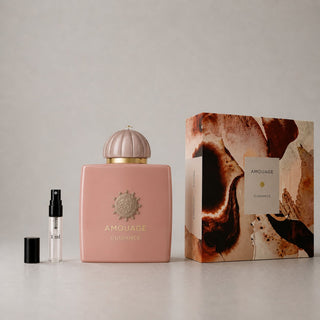Amouage Guidance Sample Spray features a pink bottle with a decorative cap and a matching box, showcasing elegant design elem