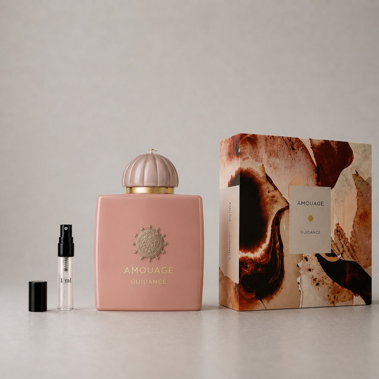 Amouage Guidance Sample Spray features a pink bottle with a decorative cap and a matching box, showcasing elegant design elem