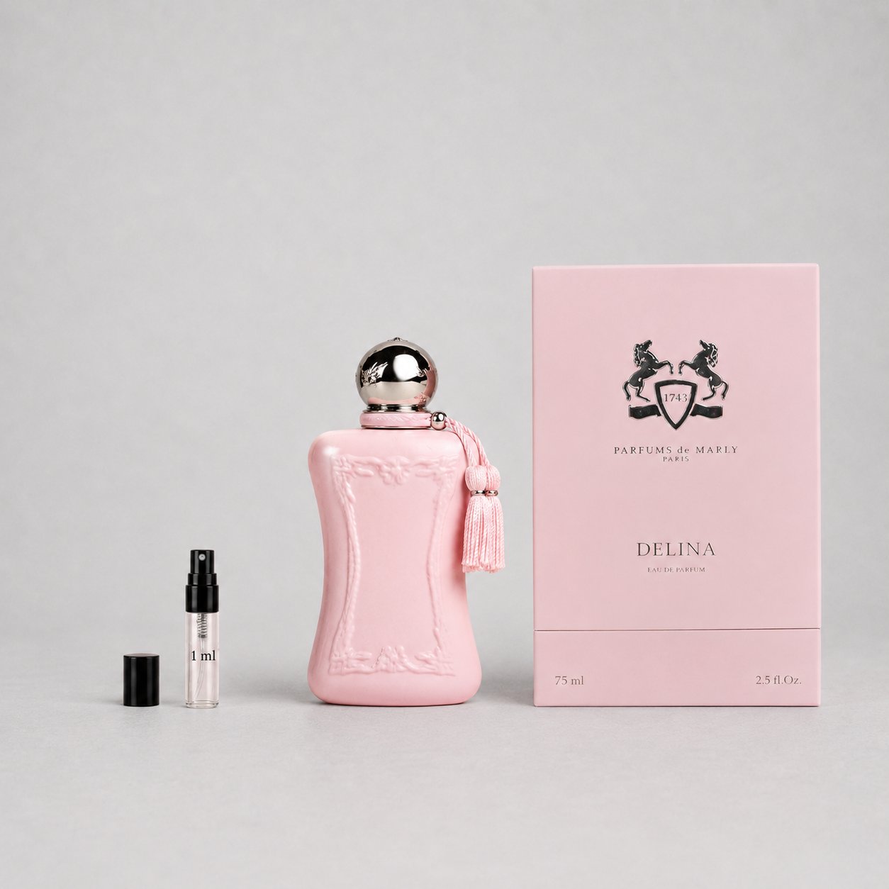 Delina Sample Spray by Parfums de Marly, featuring a pink bottle, tassel, and a small spray vial beside the box.