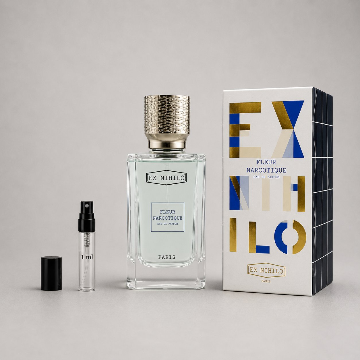Ex Nihilo Fleur Narcotique Sample Spray featuring a clear bottle with a textured cap, a small spray vial, and a geometric box
