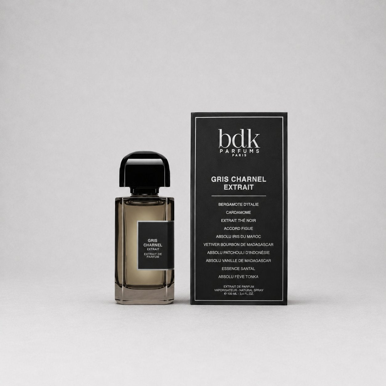 BDK Parfums Gris Charnel Sample Spray in a sleek bottle next to its elegant packaging on a gray background.