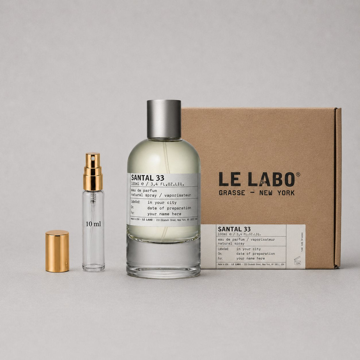 Le Labo Santal 33 Sample Spray with a glass bottle, a small spray vial, and a cardboard box. Elegant and minimalist design.