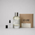 Le Labo Santal 33 Sample Spray featuring a glass bottle, small spray vial, and a cardboard box.
