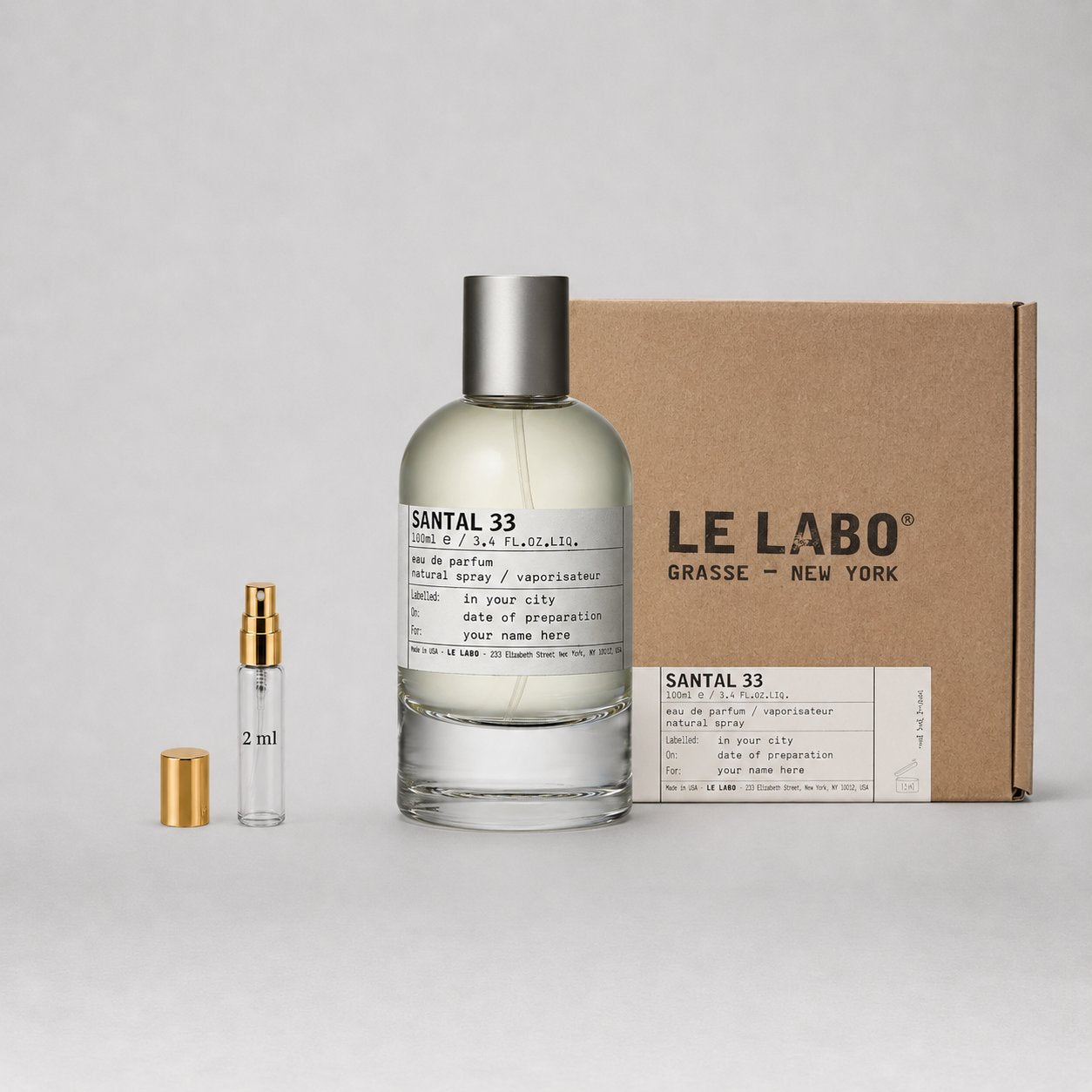 Le Labo Santal 33 Sample Spray featuring a 2ml vial and a larger bottle, packaged in a brown box with brand label.