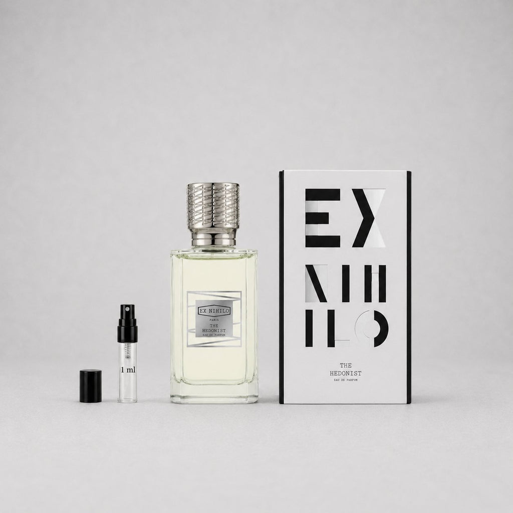 Ex Nihilo The Hedonist Sample Spray featuring a clear bottle with a textured silver cap, a small vial, and a stylish box.