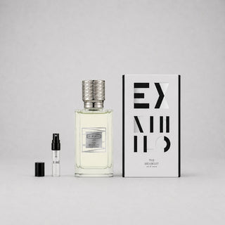 Ex Nihilo The Hedonist Sample Spray featuring a clear bottle with a textured silver cap, a small vial, and a stylish box.