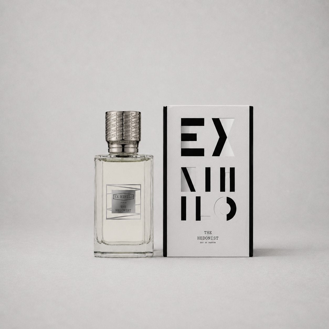 Ex Nihilo The Hedonist Sample Spray in a clear bottle next to a stylish black and white box featuring modern typography.